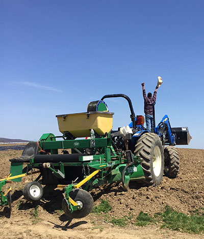 blue skies over worker and farm machine