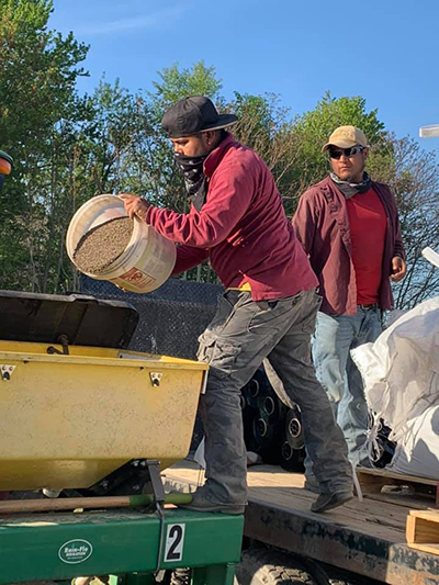 men pouring fertilizer