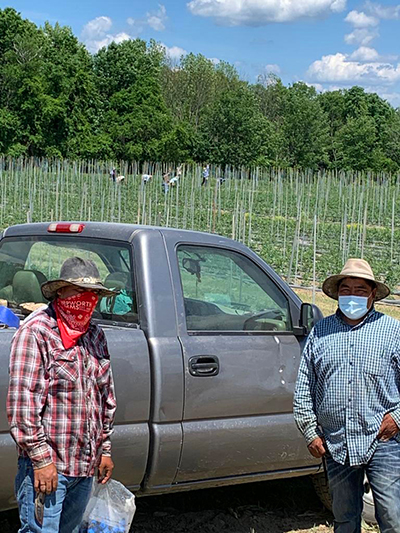 two men by truck with face masks